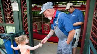 Little girl gives her ticket to conductor before boarding Pullen Park train