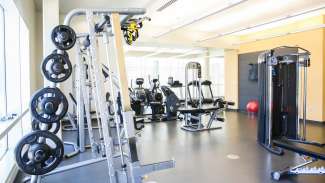 Fitness room at Abbotts Creek Park with multiple machines, cardio equipment and free weights. 