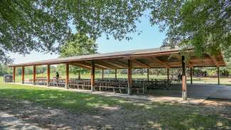 A very large picnic shelter with several tables located near the restrooms at Anderson Point Park 