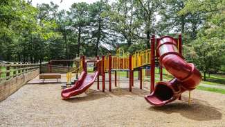 Playground with slides, swings and more on a woodchip surface at Biltmore Hills Park 