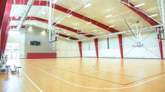 A wide shot of the Halifax Park gymnasium with basketball courts and hoops