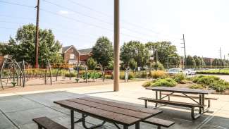 An outdoor covered patio with picnic tables next to the playground at Halifax Park