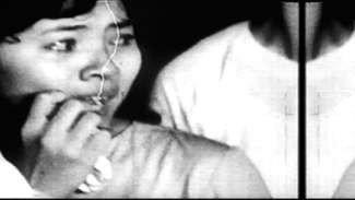 A still from Adaptation Fever by Hồng-Ân Trương of a woman looking to the left, scared. 