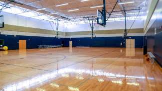 An open gymnasium with multiple courts and basketball hoops 