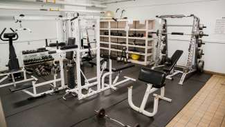 Method Road Park fitness room featuring weights, workout machines and treadmill.