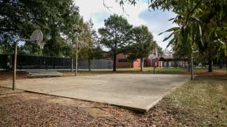 Outdoor basketball court at Method Road Park shows concrete court and two basketball hoops.