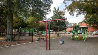 A playground at Method Road Park with swings, slides, climbing equipment and more 