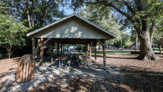 An outdoor picnic shelter with six tables and a grill at tarboro road 