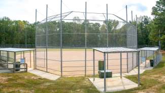 A large open field used for softball with lighting 