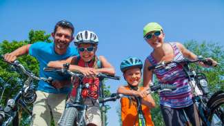 Family on bikes smiling at camera