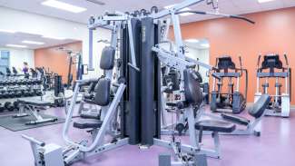 A fitness room with machines, free weights and cardio equipment 
