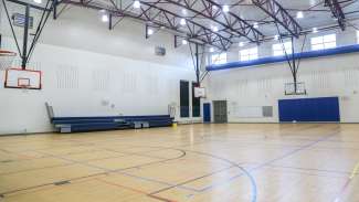A large open gymnasium with multiple basketball hoops