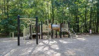 An outdoor large open playground with slides and monkey bars