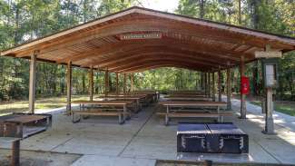 A large outdoor picnic shelter with grills 