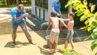 Kids playing with a water hose during a summer camp