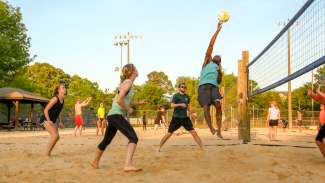 A group of young adults playing sand volleyball at Jaycee Park 