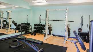 A weight room with free weights and workout equipment 