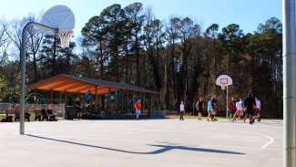 An outdoor basketball court with a concrete surface 