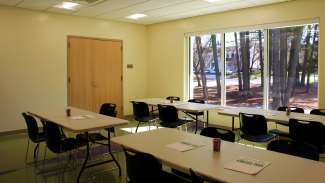 A smaller meeting room with tables and chairs 