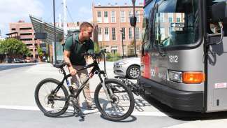 Man getting ready to load bike on bus rack