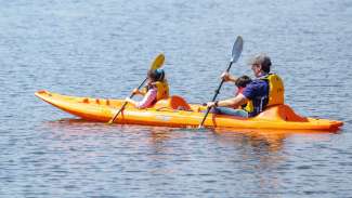 Man and two girls kayaking on Lake Wheeler