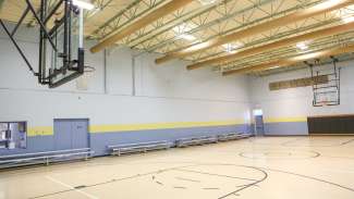 An indoor gymnasium with basketball court 