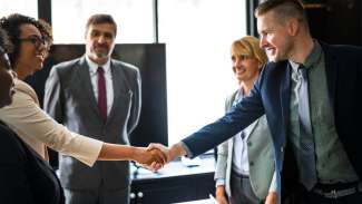 people shaking hands in business attire