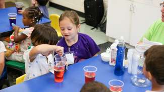 Kids participating in a science experiment during a summer camp 