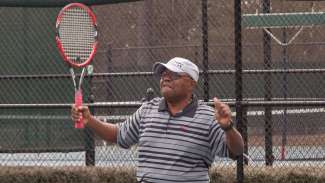 An older adult playing tennis 