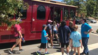 Group of people loading onto the historic Raleigh Trolley for a tour