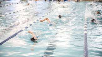 A bunch of kids swimming laps 