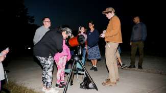 A group looking through a telescope during the astronomy nights program 