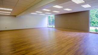 Meeting room at Biltmore Hills community center with wooden floors and windows