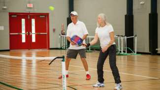Two adults playing pickleball 