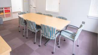 A conference room with a large table and eight chairs 