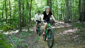 Two people riding their mountain bikes on a trail 