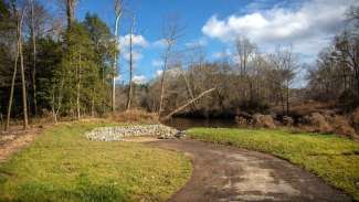 Sidewalk trail leading to sloping river access launch into the Neuse River 