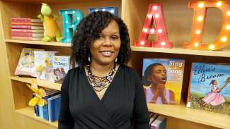 2021 Piedmont Laureate Kelly Starling Lyons stands in front of book shelf