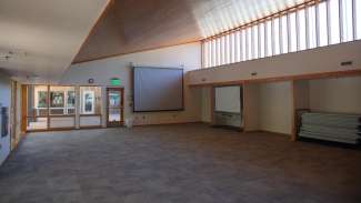 A second large open room with a projector and lots of windows 