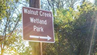 A sign pointing to the Walnut Creek Wetland Park