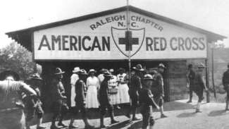 Historic photography of Raleigh red cross building with people outside