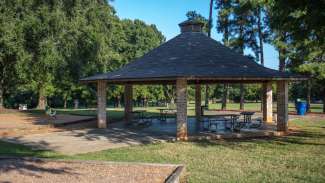 A large, open picnic shelter with multiple tables 