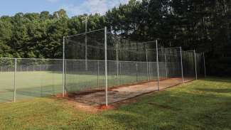 A batting cage next to the youth baseball field 