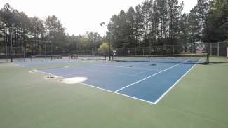 A wide shot that shows two of the tennis courts at the park 