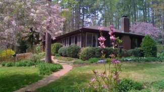 House surrounded by blooming flowers and green grass