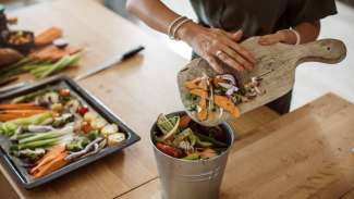 Person putting food waste into bucket