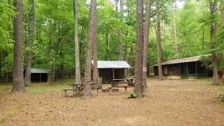 Campsite with wooden benches and wooden cabins