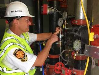 fire inspector checking gauges on some pipes