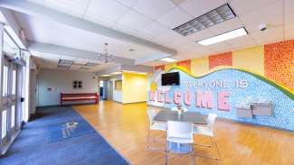 Community center hall with mural that says, "Everyone is welcome."