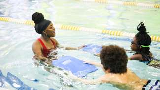 Instructor and two children in pool during swim lesson